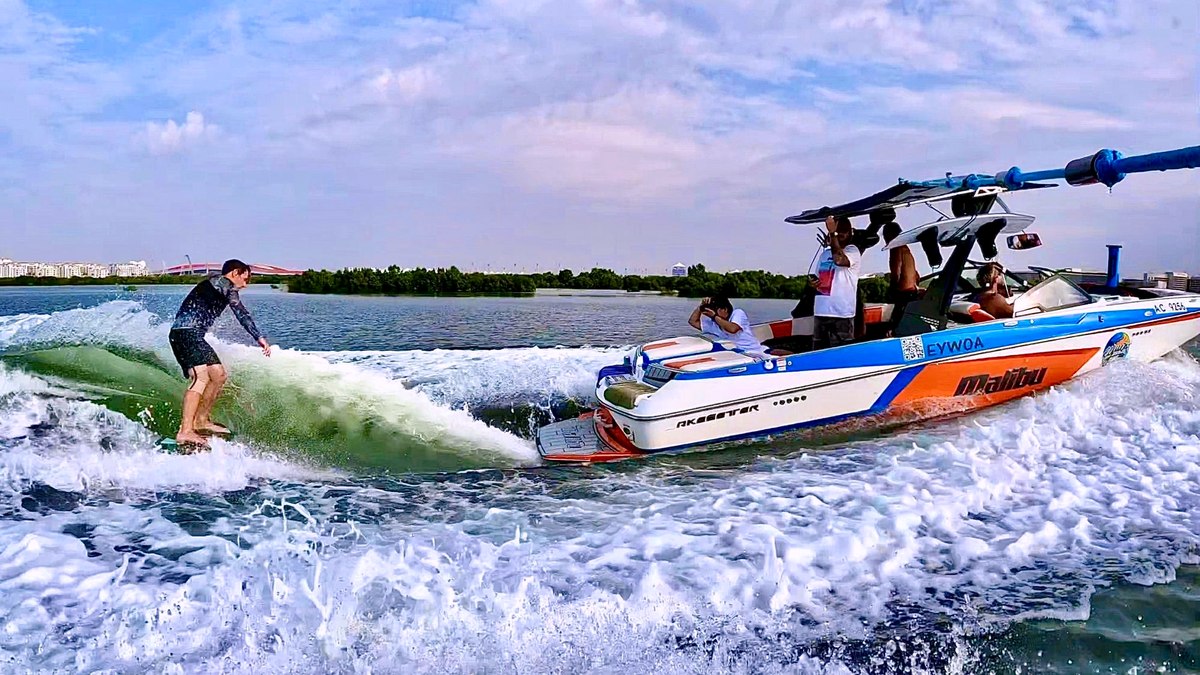 Wakesurfer riding the wave behind the Eywoa Malibu boat near Yas Island Abu Dhabi