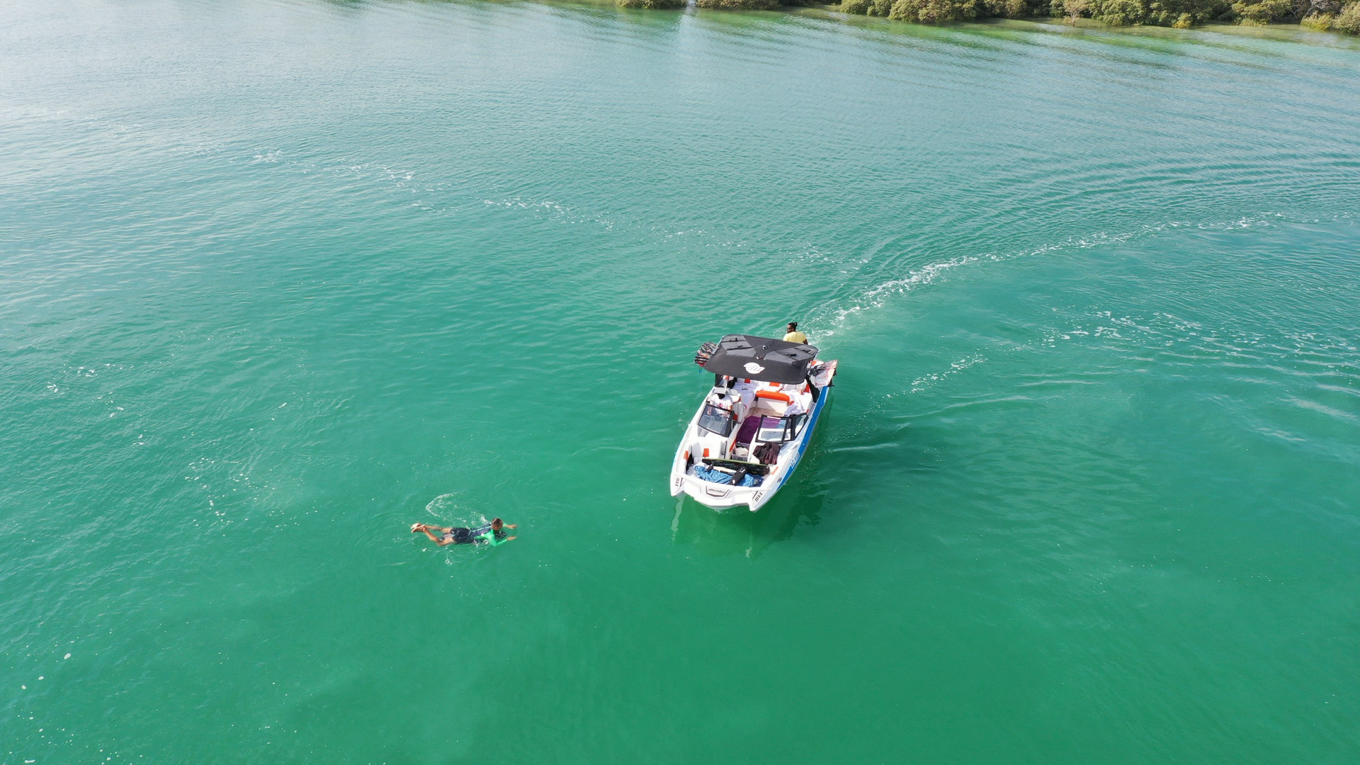 Rider carving a wakesurf wave behind a Malibu boat in the mangrove channels near Yas Island, Abu Dhabi