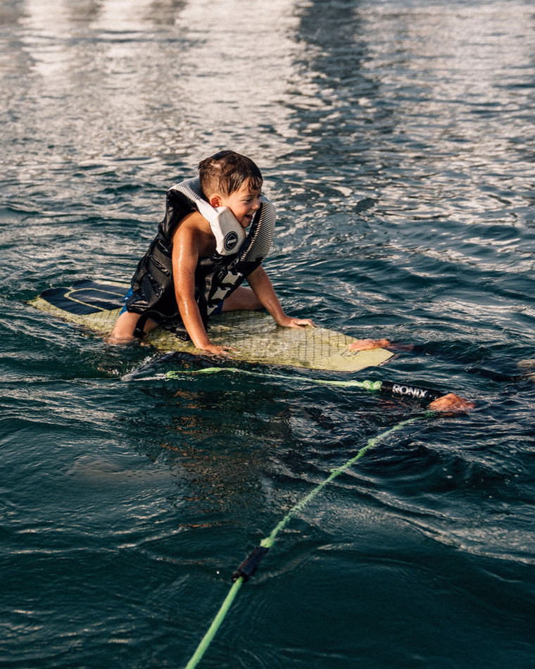 Eywoa coach teaching a child to wakesurf near Yas Marina, Abu Dhabi