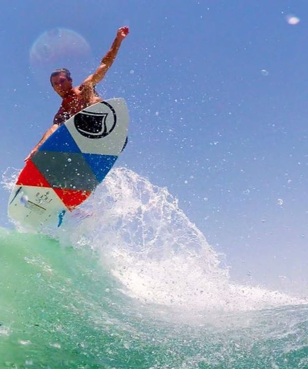 Rider does an air grab on a Liquid Force wakesurf board